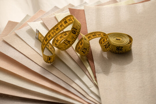Yellow measuring tape on layered felt swatches for sewing and textile design
