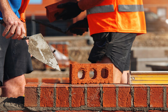 Bricklayers laying a wall at a construction site during daytime