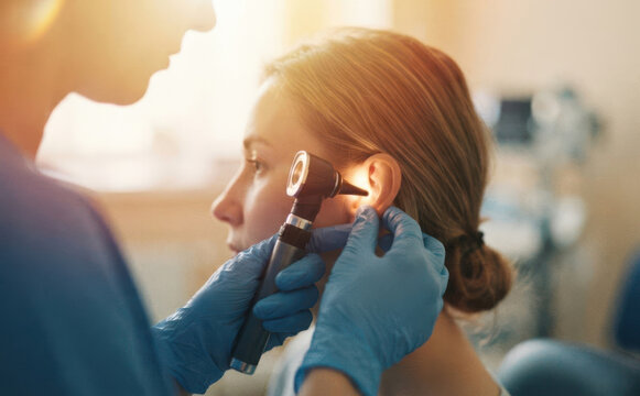 Female adult patient having her ear examined by a doctor with an otoscope in a medical clinic for health checkup