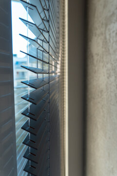 Close-Up of Dark Horizontal Window Blinds with Soft Natural Light and Warm Shadows
