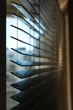 Close-Up of Dark Horizontal Window Blinds with Soft Natural Light and Warm Shadows
