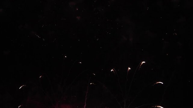 Bright red and golden fireworks exploding in dark night sky, representing grand celebration, New Year event, anniversary party, festival, Independence Day, and holiday background concept
