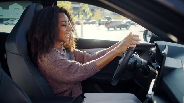 Happy woman driver enjoys new car while holding steering wheel