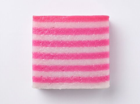 Slice of traditional pink and white layered steamed cake on white 4k