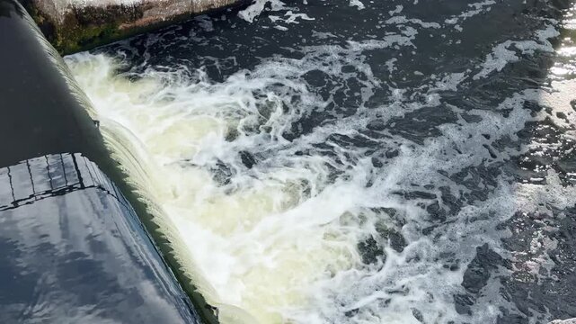 Water Level Control Structure Releasing Water into a River, Turbulent Flow and White Foam, 4K 60fps