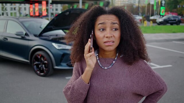 Upset African American woman speaks with automotive specialist