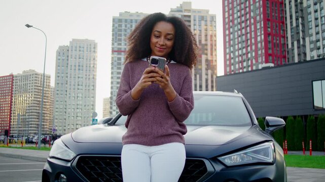 Cheerful woman smiles warmly as types message on smartphone