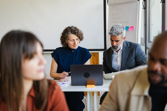 Professionals are engaged in their tasks within the open workspace