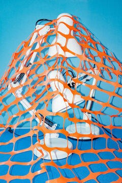 Robot surrounded by orange mesh on blue background