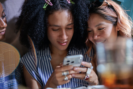 Women smiling while looking at a smartphone