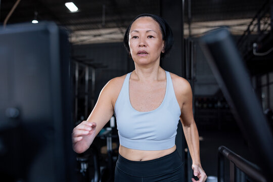 Woman runs on a treadmill at the gym
