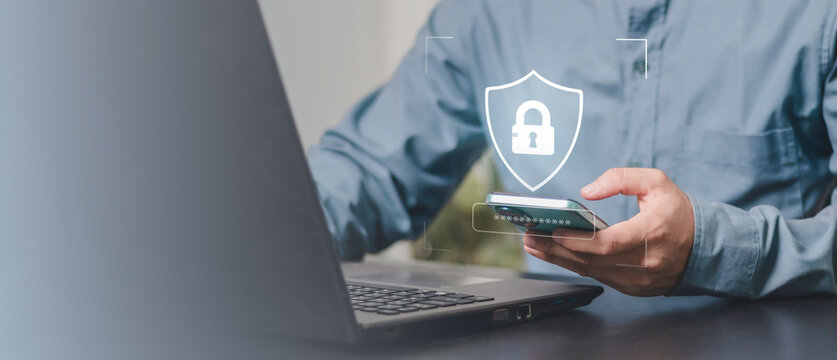 Data privacy mobile, secure login, password, and digital protection. Cybersecurity concept with a user entering a password on a smartphone beside a laptop, shield and lock icon.