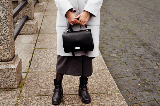 Cropped shot of woman standing at the street and holding a bag