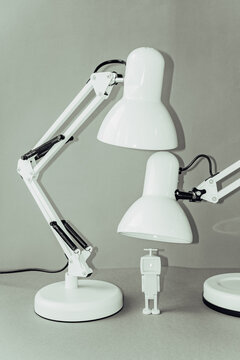 Two white lamps and a small figure in a simple setting