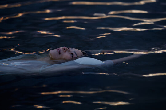 Person Floating on Water During Evening Hours