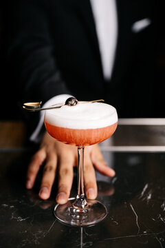 Bartender pushes cocktail toward you