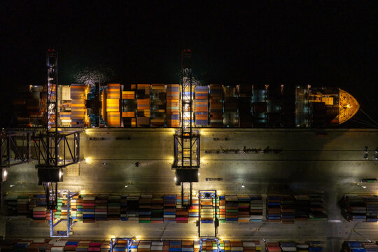 Container ship at port during nighttime operations