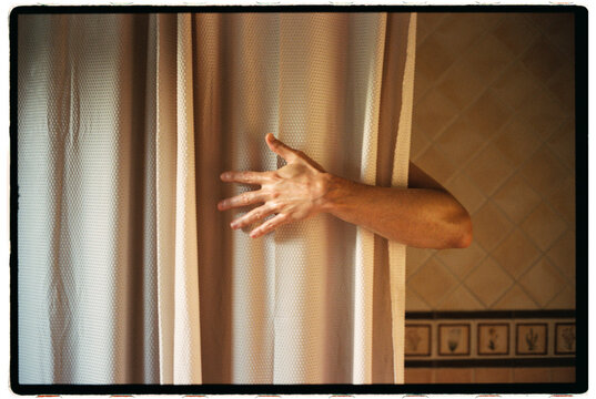 Person Reaching for a Curtain