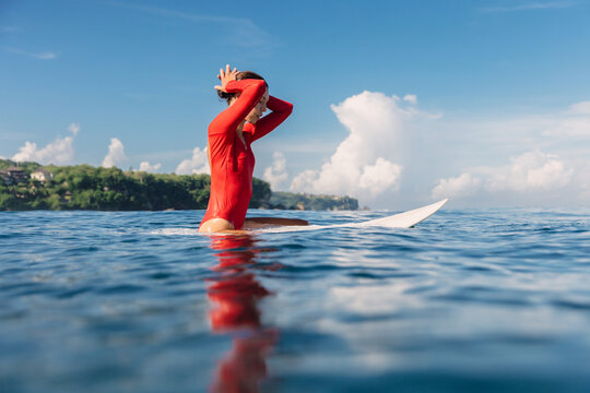 Surfer woman on surfboard in sea. Surfer woman in water on sunny day