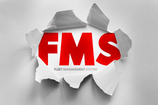 FMS acronym for fleet management system revealed through torn paper. Logistics and transportation concept for tracking, maintenance, and optimization of commercial vehicle operations daily