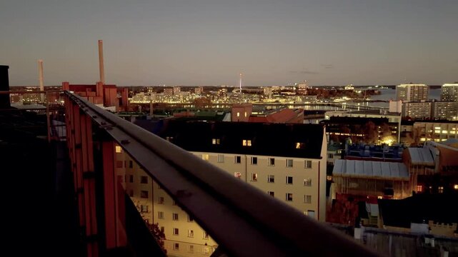Helsinki City Lights at Night from a Rooftop Railing in Kallio