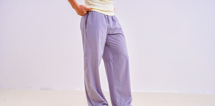                               Asian athletic male model in light purple loose casual trousers, studio apparel photo on plain background 
