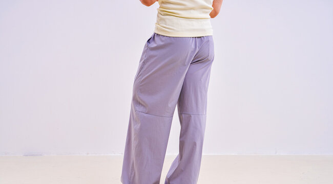                               Asian athletic male model in light purple loose casual trousers, studio apparel photo on plain background 