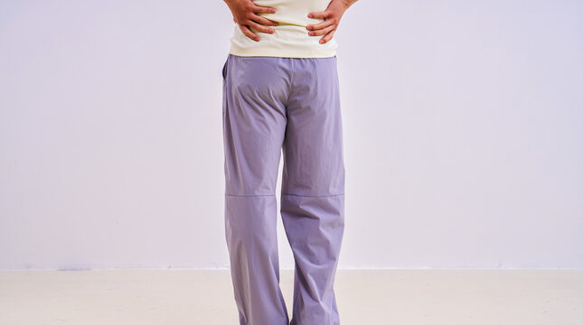                               Asian athletic male model in light purple loose casual trousers, studio apparel photo on plain background 