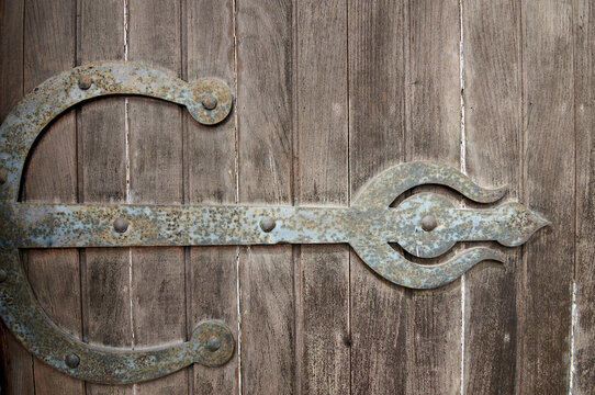 A very old door. Detail of a hinge