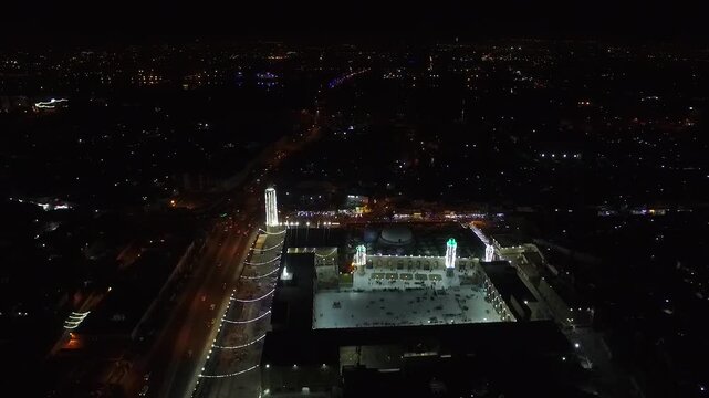 Illuminated night aerial of the illuminated Sheikh Abdul Qadir al-Gilani Mosque at night in Baghdad, Iraq