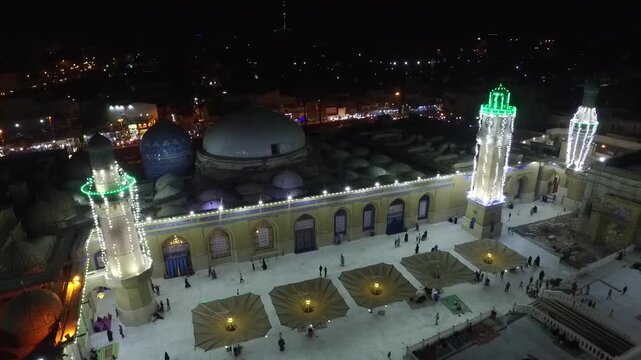 Drone footage at night of the illuminated Sheikh Abdul Qadir al-Gilani Mosque at night in Baghdad, Iraq