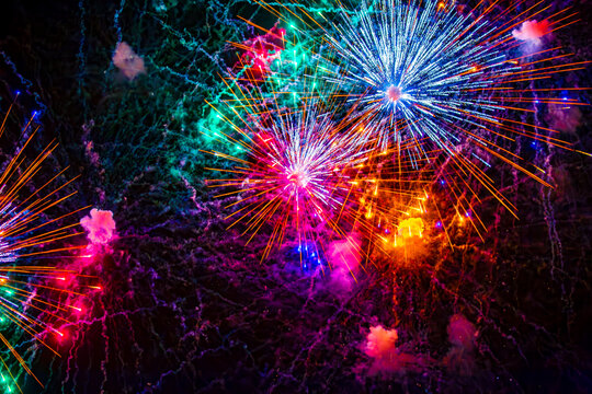 Fireworks close-up. Multicolored fireworks in the night sky, bright festive background with space for text.