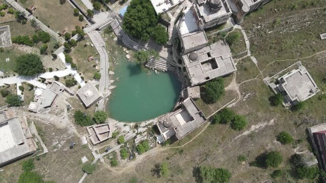 Overhead drone video clip capturing the heart-shaped sacred water pool, stone steps, and historic Hindu temple structures at Katas Raj complex.
