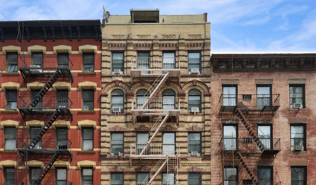 New York City, colorful apartment building facades with external fire escape ladders