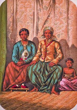 Seated Javanese family with father, mother and child, traditional clothing, headscarf, jacket, long skirt, shoes, barefoot, earrings, necklace, belt, interior with raffia rug, coloured drawing, Java, historical illustration 1877