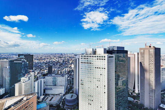 青空と白い雲が広がる新宿の高層ビル群の眺望