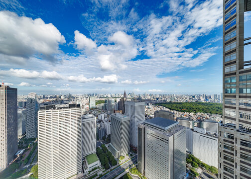 青空と白い雲が広がる新宿の高層ビル群の眺望