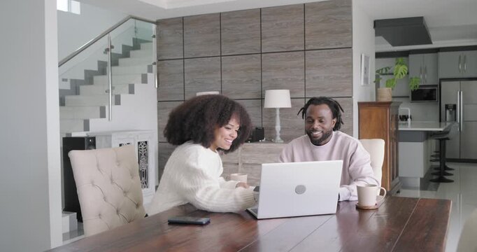 African American couple checking papers at home, woman showing pages, typing laptop, celebrating