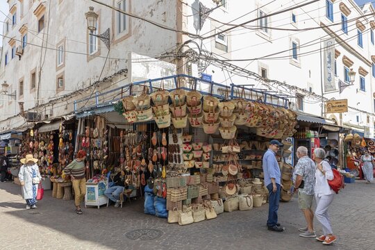 Outdoor market stalls selling traditional crafts and baskets in a sunny urban area