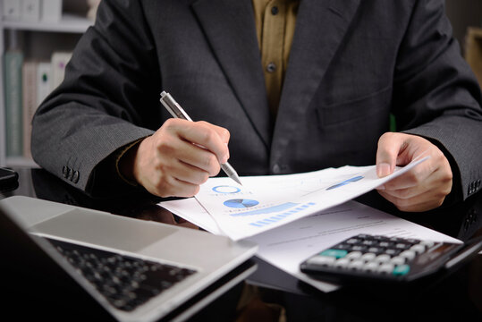 Business Finance Analysis with Calculator Laptop and Printed Charts for Budget Planning Accounting Review and Financial Reporting