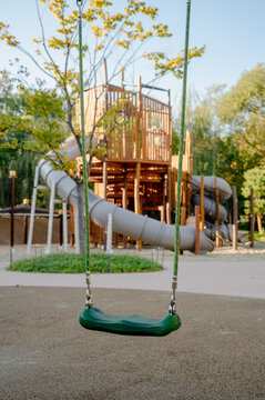 야외 어린이 놀이터에 있는 빈 초록색 그네와 미끄럼틀 놀이기구(Empty green swings and slide play equipment at outdoor children playground in Korea)