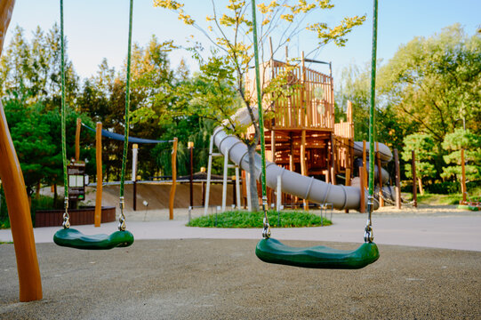 야외 어린이 놀이터에 있는 빈 초록색 그네와 미끄럼틀 놀이기구(Empty green swings and slide play equipment at outdoor children playground in Korea)