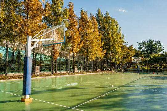 맑고 푸른 하늘 아래 공원에 위치한 빈 야외 농구장(Empty outdoor basketball court in a park under clear blue sky in Korea.)