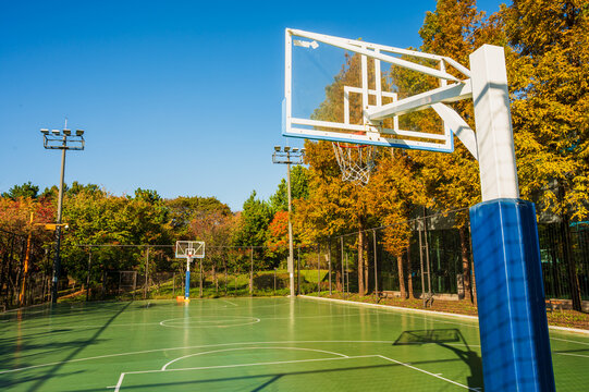 맑고 푸른 하늘 아래 공원에 위치한 빈 야외 농구장(Empty outdoor basketball court in a park under clear blue sky in Korea.)