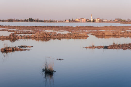 View of the small town of Lio Piccolo among the salt marshes in the Venetian lagoon at sunset