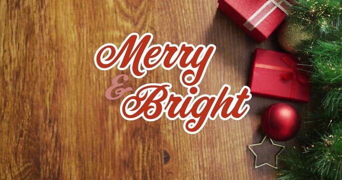 Displaying hand-lettered Merry  and  Bright greeting on wooden planks, with fir, wrapped gifts, baub