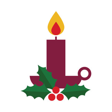 Holiday candle burning brightly inside a dark holder decorated with festive green holly leaves