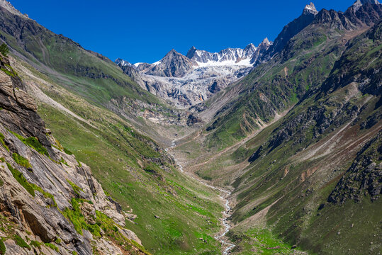 Panoramic view of glacial u-shaped valley having snow cladded peaks, glaciers and moraines  deposited by glacier in high altitude Himalayas mountain region of Himachal Pradesh, India.