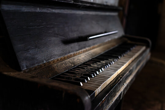 Old broken piano and chair in abandoned ruined mansion. Haunted house interior