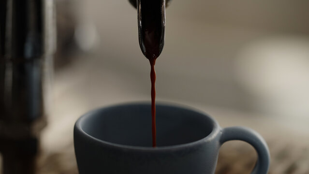 closeup espresso pour in ceramic cup